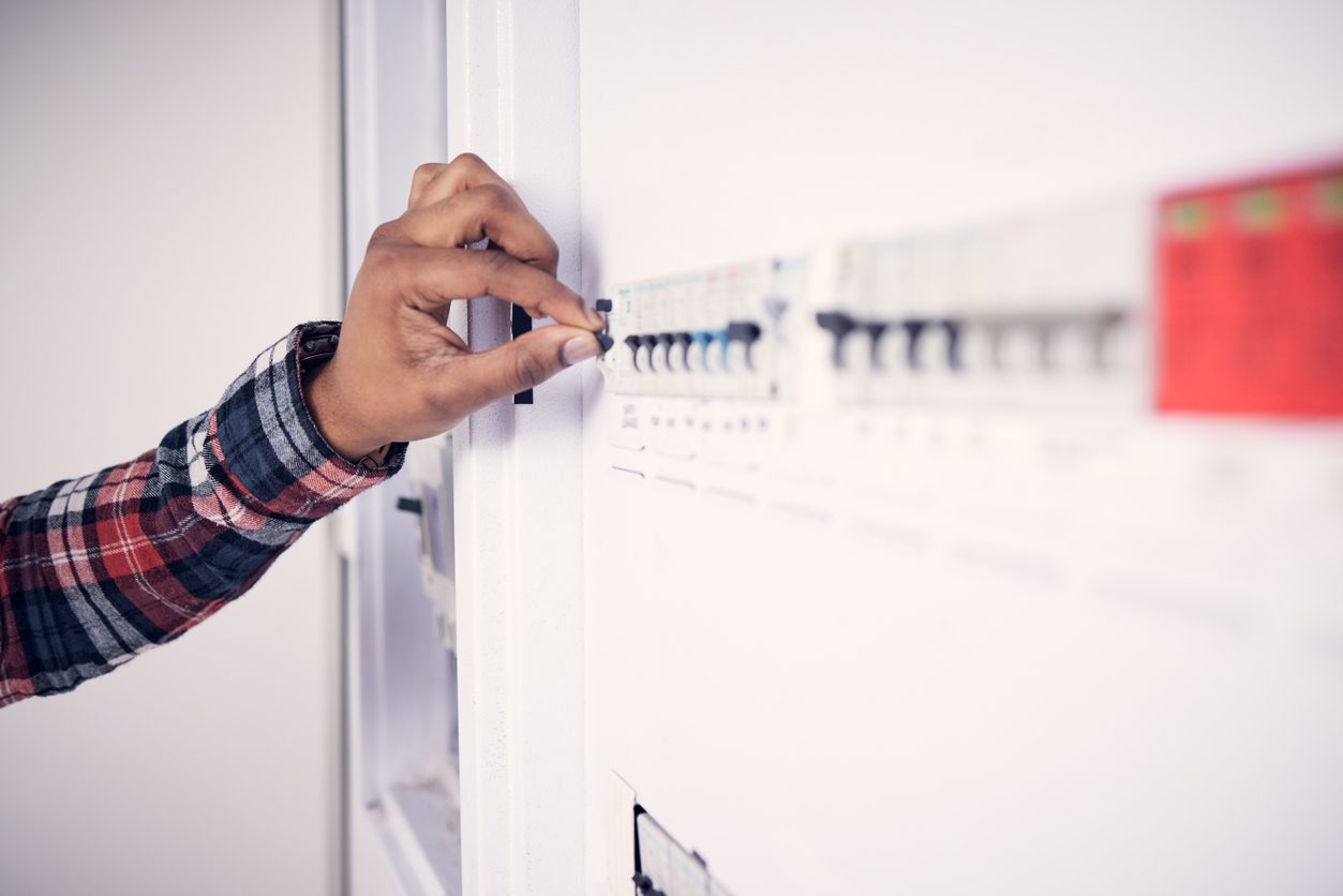 Man, hand and electrician with electricity fuse box, check power supply with maintenance on main circuit breaker switch. Engineer, technician and male worker with handyman and electrical fix
